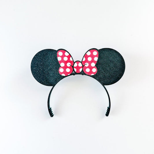 Black mouse ears headband with a red polka dot bow on a white background