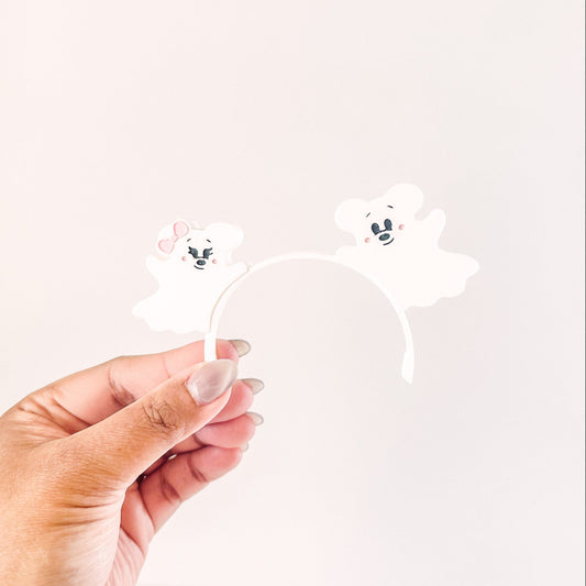 Hand holding a clear acrylic stand with cartoon character designs on a white background