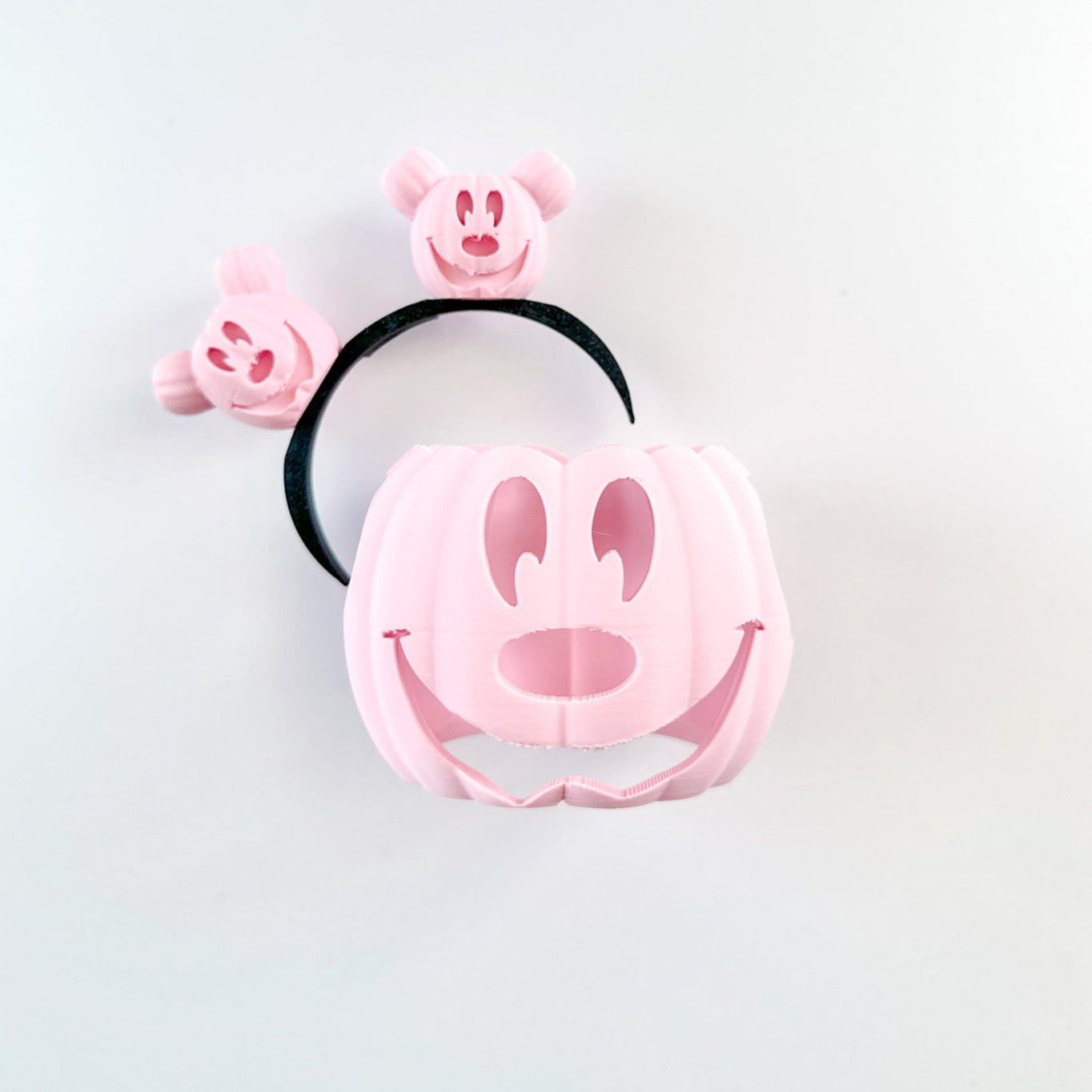 Pink hair accessory with a smiley face design on a white background