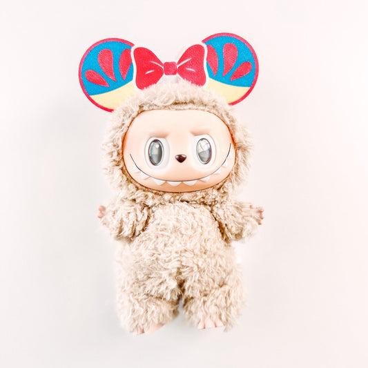 Plush toy with colorful bow ears on a white background